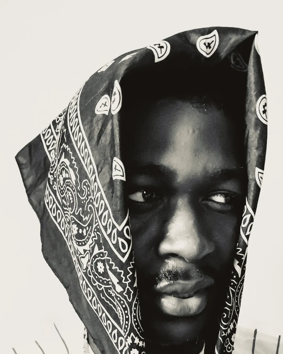 TWHLV, photographed in monochrome, a patterned bandana drawn around the head.